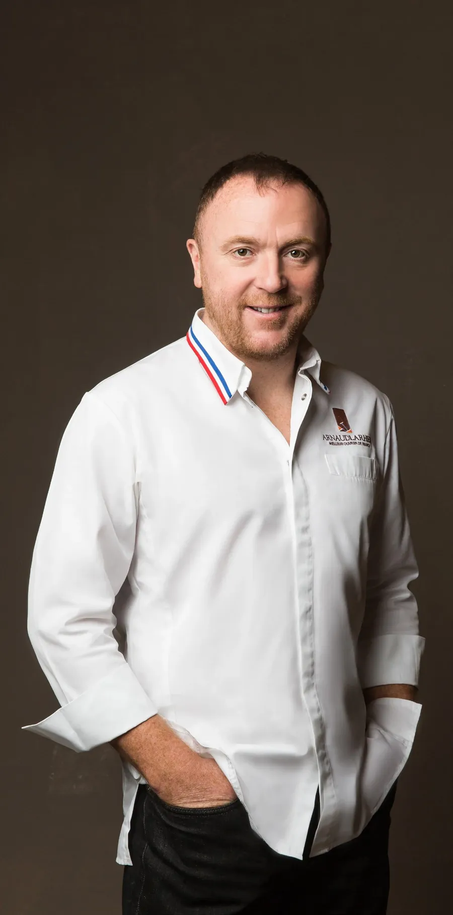 Arnaud Larher, Meilleur Ouvrier de France Pâtissier, con chaqueta blanca de cocina y cuello tricolor, foto de Fauchon