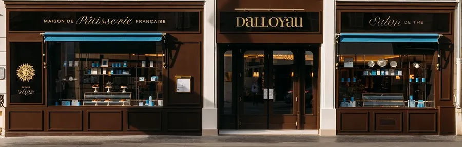 Fachada de Dalloyau en el 101 rue du Faubourg-Saint-Honoré, de madera marrón oscuro con toldos azules y el salón de té a la derecha, foto de Dalloyau