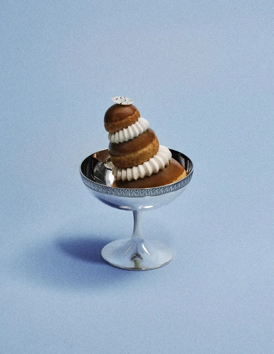 Religieuse de Dalloyau en una copa de plata ante un fondo azul claro, foto de Dalloyau