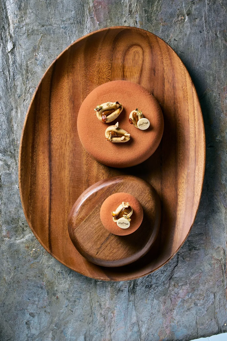 Velours noisette de Lenôtre en tamaño para compartir e individual sobre una bandeja de madera, foto de Lenôtre